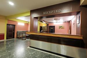 a hotel lobby with a reception counter and a mirror at Landmark INN in Kāsaragod