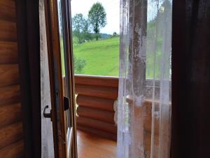 an open door with a view of a green field at Stream House in Lopushnoye +13 photos