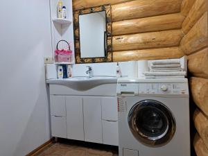 a bathroom with a washing machine and a sink at Stream House in Lopushnoye