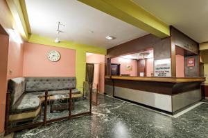a waiting room with a bench and a clock on the wall at Landmark INN in Kāsaragod