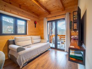 a living room with a couch and a balcony at Wooden Villa Old Oak Plitvice Lakes in Seliste Dreznicko