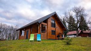 a house with three chairs in front of it at Wooden Villa Old Oak Plitvice Lakes in Seliste Dreznicko