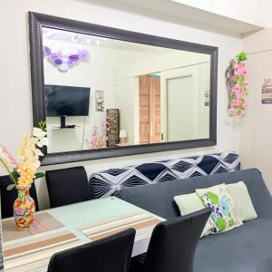 a living room with a table and a mirror at Dvine Era Staycation in Manila