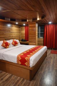 een slaapkamer met een groot bed met rode gordijnen bij Mall Road Hotel B - Annecy - Free Wifi & Restaurant Facilities - Premium Rooms - Best Location Hotel In Darjeeling in Darjeeling