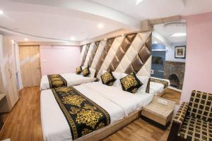 een slaapkamer met een groot bed met een hoofdeinde bij Mall Road Hotel B - Annecy - Free Wifi & Restaurant Facilities - Premium Rooms - Best Location Hotel In Darjeeling in Darjeeling +13 foto's