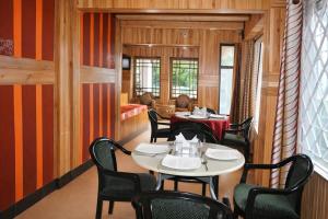 een restaurant met tafels en stoelen in een kamer bij Mall Road Hotel B - Annecy - Free Wifi & Restaurant Facilities - Premium Rooms - Best Location Hotel In Darjeeling in Darjeeling
