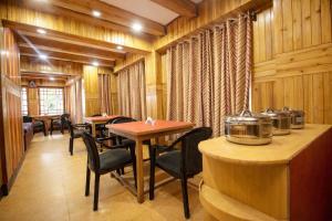 een restaurant met houten wanden en tafels en stoelen bij Mall Road Hotel B - Annecy - Free Wifi & Restaurant Facilities - Premium Rooms - Best Location Hotel In Darjeeling in Darjeeling