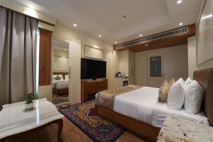 a hotel room with a bed and a television at Hotel Maharaja Palace Rohtak in Kahrāwar