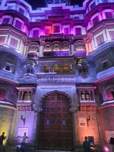 a building with purple lights on top of it at Narmada Gest House in Indore