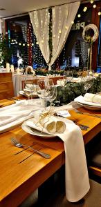 a wooden table with wine glasses and plates on it at MOTOREST-PENSION U HRACHŮ,s.r.o. in Klatovy