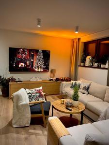 a living room with a couch and a tv at Orchidea Willa Pienińska in Sromowce Wyżne