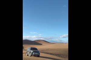 een auto geparkeerd in het zand in de woestijn bij Chegaga Infinite Dunes Luxury Desert Camp in Mhamid +2 foto's
