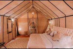 een slaapkamer met een groot bed in een tent bij Chegaga Infinite Dunes Luxury Desert Camp in Mhamid
