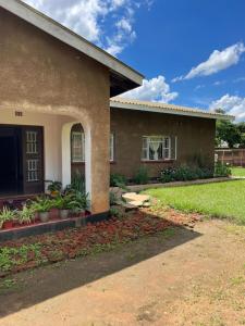 a house with a grass yard in front of it at Suzie's Nest in Lilongwe