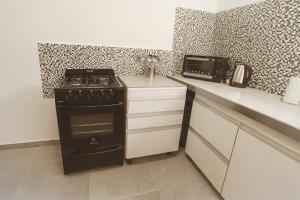 una cucina con piano cottura nero e forno a microonde di Departamento LUNA NUEVA a Santa Clara del Mar Altre 11 foto