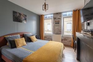 a bedroom with a bed and two windows at comme un air de chez soi in Calais