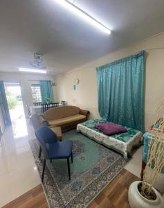 un soggiorno con un letto e un divano di D'Ashikin Village Stay a Seremban