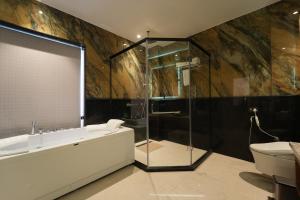 a bathroom with a shower and a tub and a sink at Hotel Maharaja Palace Rohtak in Kahrāwar +44 photos