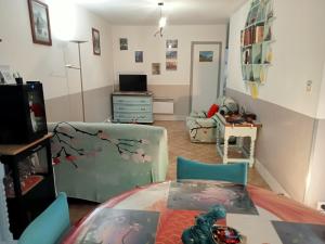 een woonkamer met een tafel en een eetkamer bij une pause quelque part au jardin des érables et des niwakis in Saint-Médard-de-Guizières