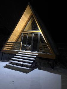 a house with a staircase in the snow at Aurora Cottage Tabatskuri Lake in Tabatsquri