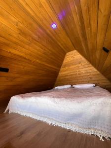a bedroom with a bed in a wooden room at Aurora Cottage Tabatskuri Lake in Tabatsquri