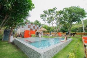 a swimming pool with two people in the water at บ้านมะนาวรีสอร์ท เกาะล้าน in Ko Larn