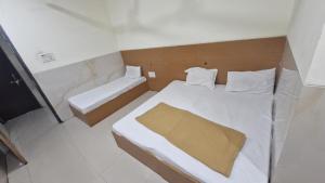 a small room with a bed and a tub at RK Hotel in Boisar