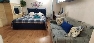 een slaapkamer met een bed en een bank bij Ribero's Home - Center - Quite Zone in Sanremo