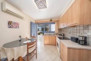 een keuken met een tafel en een aanrechtblad bij Makis Dream Apartments - Artemis in Vlachata