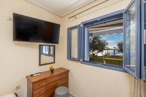 een kamer met een raam en een flatscreen-tv bij Makis Dream Apartments - Artemis in Vlachata
