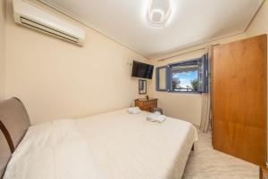 een slaapkamer met een wit bed en een raam bij Makis Dream Apartments - Artemis in Vlachata