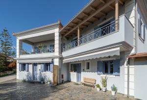 een wit huis met een bankje ervoor bij Makis Dream Apartments - Artemis in Vlachata