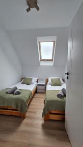 een slaapkamer met twee bedden en een raam bij Na Skarpie in Frydman