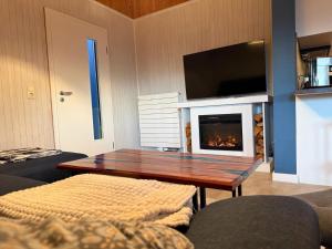 a living room with a table and a fireplace at Suedseeurlaub2 - Ferienhaus in Otterndorf in Otterndorf