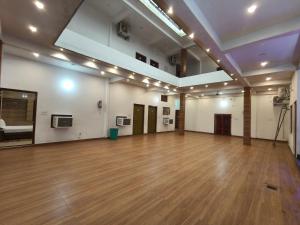a large room with a wooden floor and white walls at The Laxman Palace in Ayodhya