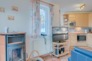 a kitchen with a living room with a tv and a couch at Strandhaus Thiessow, Wohnung mit 2 Bädern in Thiessow