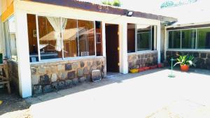 a brick house with a front door and windows at Casa De Piedra Le Petit Chalet in San Clemente