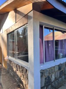 a stone building with windows and an umbrella at Casa De Piedra Le Petit Chalet in San Clemente