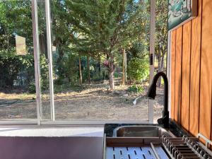 a kitchen sink and a window with a view of a yard at Casa De Piedra Le Petit Chalet in San Clemente +1 photo