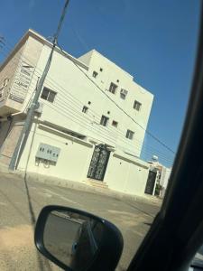 vista di un edificio dallo specchietto retrovisore laterale di un'auto di شقق رفاء a Al Ula