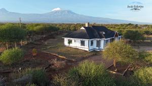 una casa in un campo con una montagna sullo sfondo di Andu Kuboiye Homes a Kimana