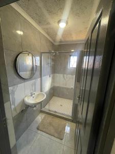 a bathroom with a shower and a sink at Eighth Avenue Self Catering Accommodation in Lüderitz