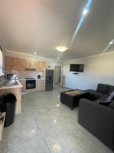 a living room with a couch and a kitchen at Eighth Avenue Self Catering Accommodation in Lüderitz