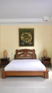 a bedroom with a wooden bed with two night stands at Ubud Wins Bungalow in Ubud