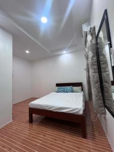 een slaapkamer met een bed in een kamer bij L&G Tourists Inn in Moalboal