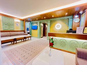 a room with a waiting area with benches and a clock at Elegance Inn in Varanasi