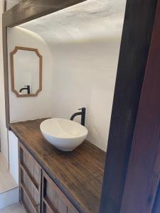 a bathroom with a white bowl sink on a wooden counter at イヤシロチomoya in Onomichi