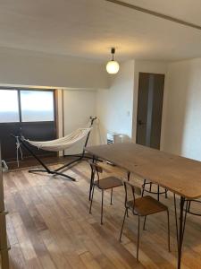 a hammock in a room with a table and chairs at イヤシロチomoya in Onomichi +14 photos