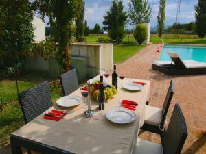 a table with plates of food and a bottle of wine at Modern holiday home in Foligno - Loc with pool in Case Vecchie