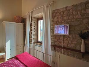 a bedroom with a tv on a stone wall at Modern holiday home in Foligno - Loc with pool in Case Vecchie